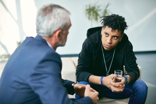 Man met grijs haar en bruingetinte jongen in gesprek