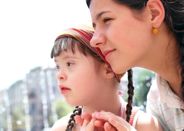 Meisje met downsyndroom en jonge vrouw kijken naar links