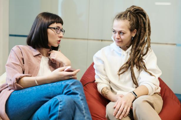 Twee vrouwen zitten op een zitzak en zijn met elkaar in gesprek