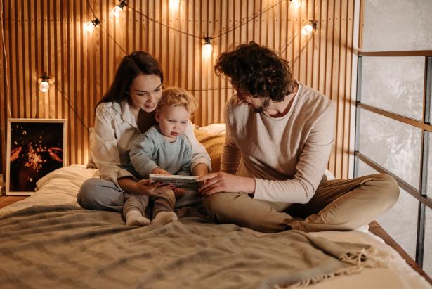 Een vader, moeder en kind op bed