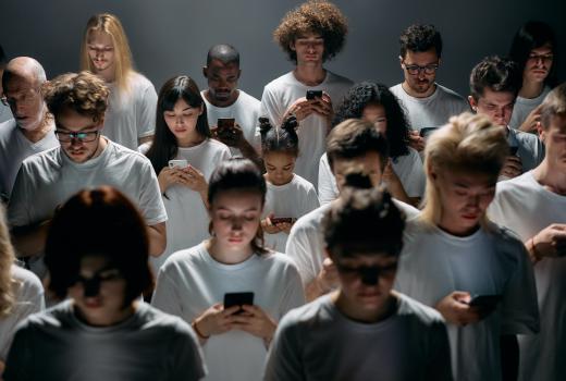 Groep mensen in wit shirt kijkt op hun smartphone